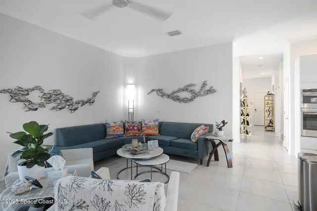 a living room with furniture flowers and a mirror