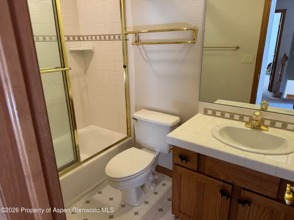 a bathroom with a sink a toilet a mirror and shower