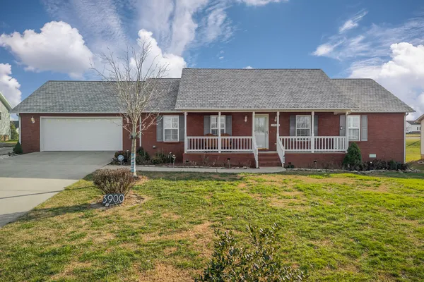 a front view of a house with a garden and yard