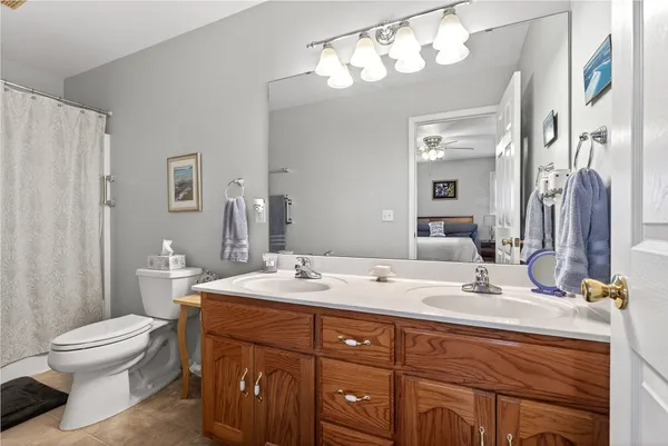 a bathroom with a double vanity sink mirror and toilet