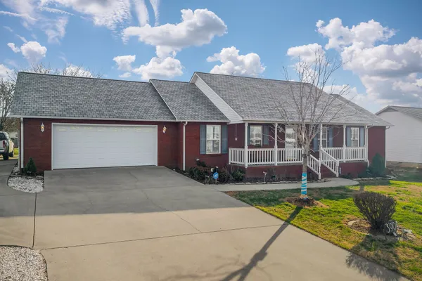 a front view of a house with a yard garage and outdoor seating