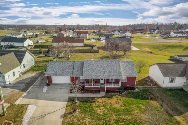 an aerial view of a house with a garden and lake view