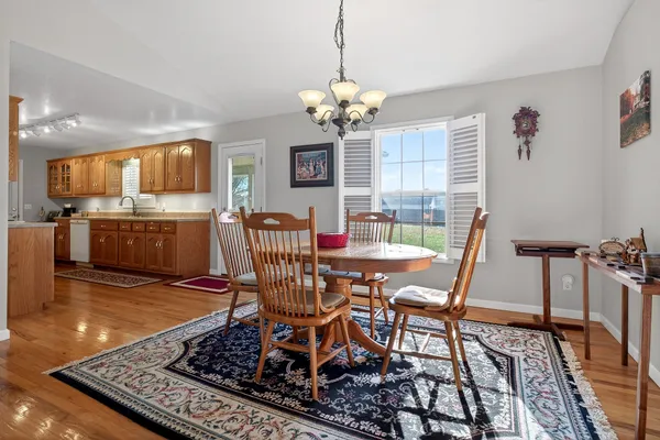 a view of a dining room with furniture a chandelier and wooden floor