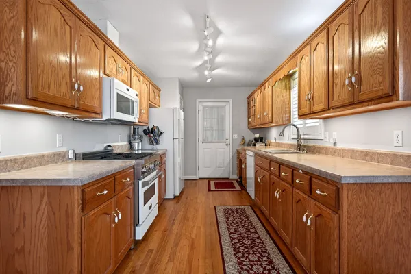 a kitchen with stainless steel appliances granite countertop wooden cabinets a sink and dishwasher