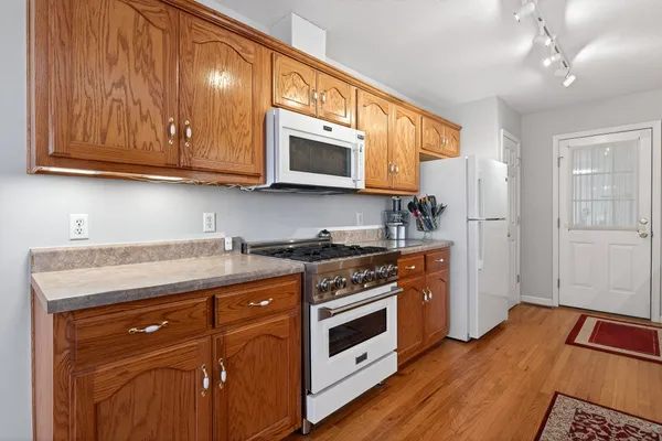 a kitchen with stainless steel appliances granite countertop wooden cabinets and a stove top oven