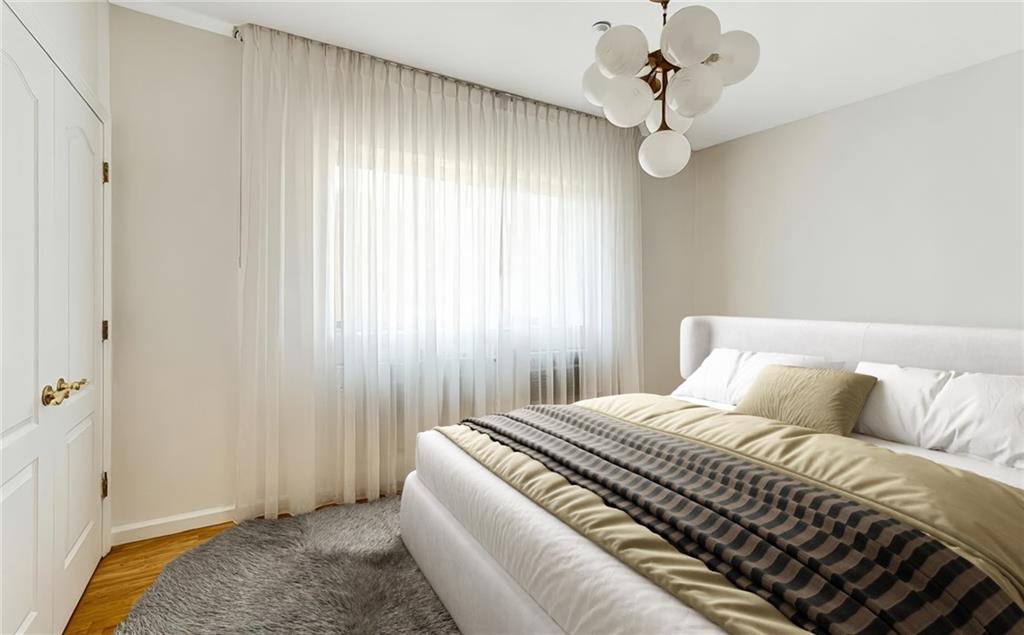 2900 East 29th Street, Unit 2E Brooklyn, NY 11235 - Photo 4 of 17 a bedroom with a bed and a chandelier