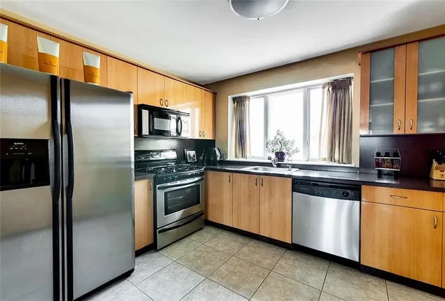 a kitchen with stainless steel appliances granite countertop a refrigerator and a sink
