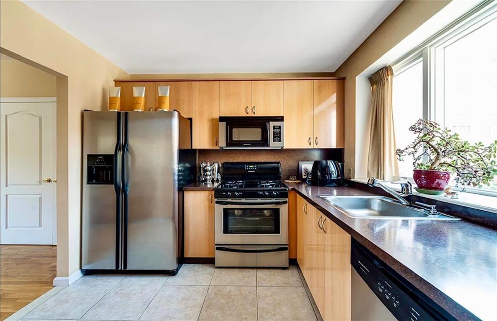2900 East 29th Street, Unit 2E Brooklyn, NY 11235 - Photo 8 of 17 a kitchen with stainless steel appliances granite countertop a refrigerator and a sink