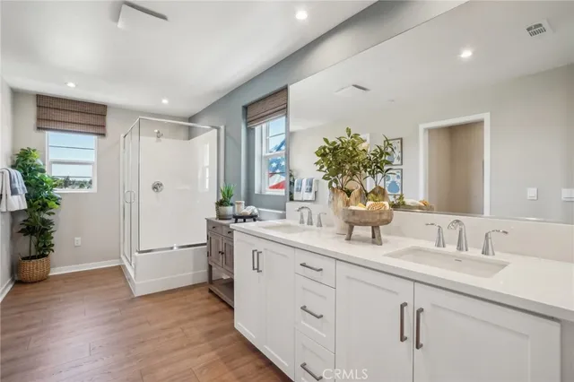 a bathroom with a double vanity sink mirror and shower