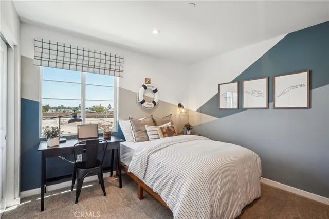 a bedroom with a bed and a large window