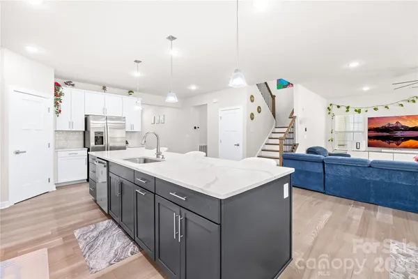 a large kitchen with kitchen island a sink a stove and a refrigerator