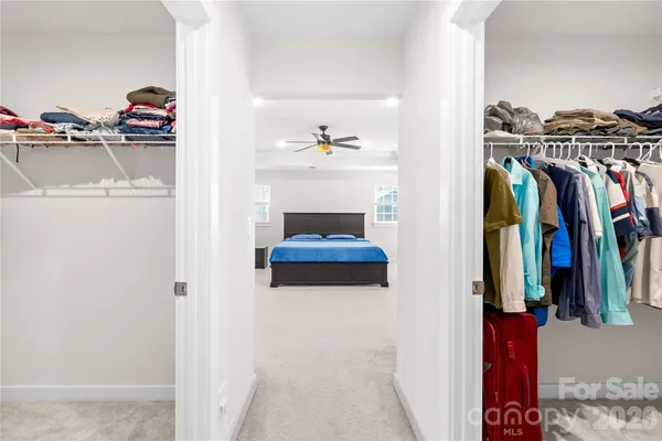a view of walk in closet with clothes and shoes
