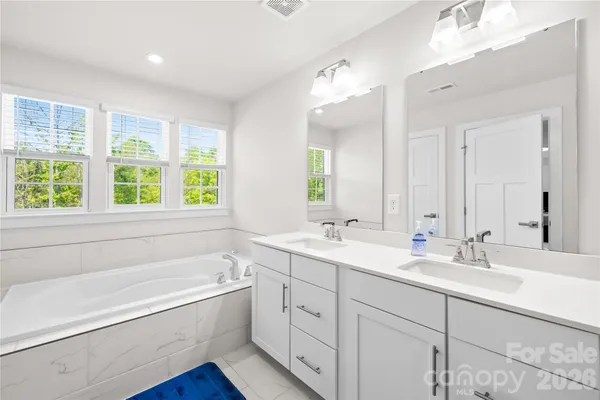 a bathroom with a tub a sink and a window