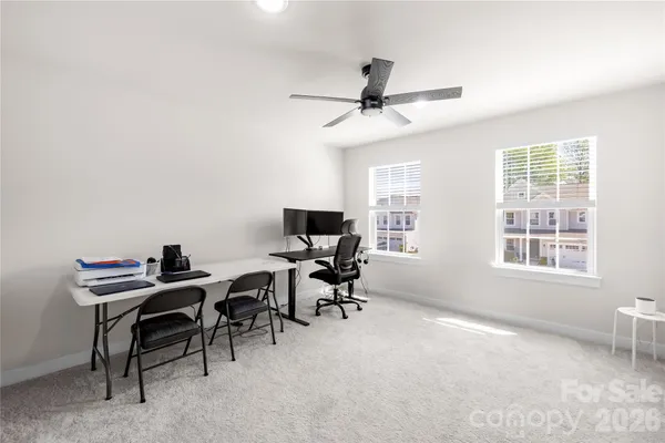 a view of a workspace with furniture and a window