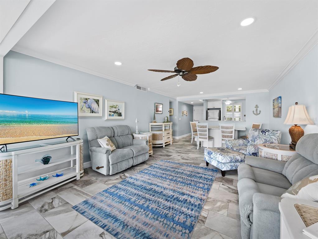 600 Sutton Place, Unit 104B Longboat Key, FL 34228 - Photo 12 of 53 a living room with furniture and a flat screen tv