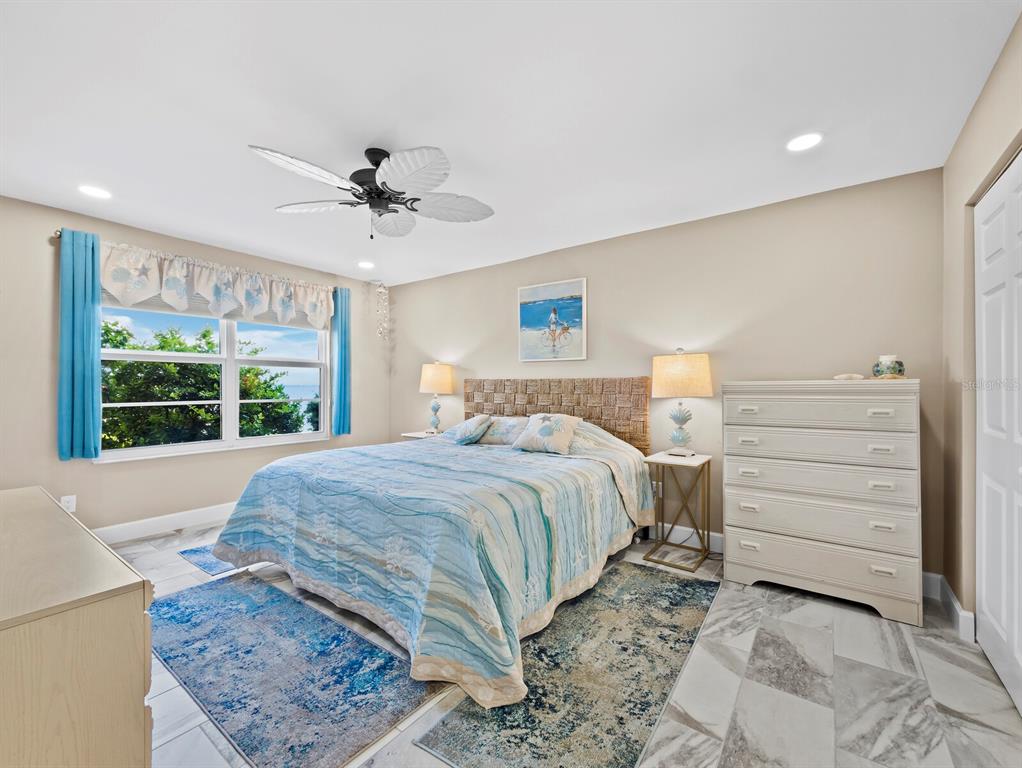 600 Sutton Place, Unit 104B Longboat Key, FL 34228 - Photo 21 of 53 a bedroom with a bed and a window