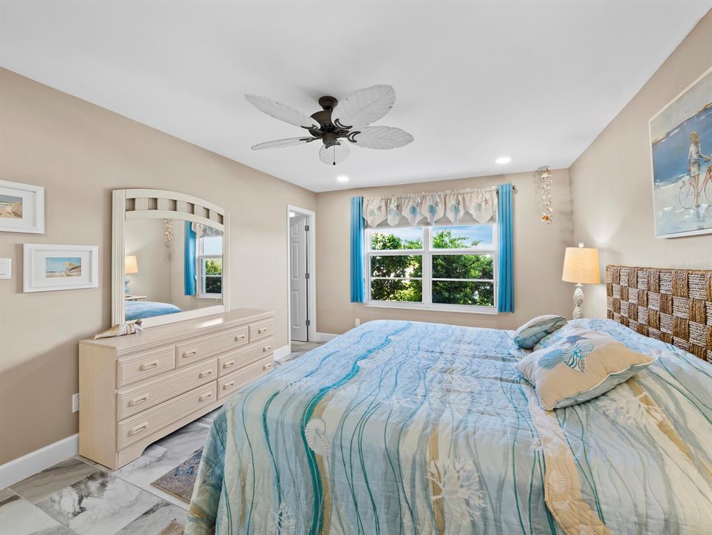 600 Sutton Place, Unit 104B Longboat Key, FL 34228 - Photo 24 of 53 a spacious bedroom with a large bed and a dresser