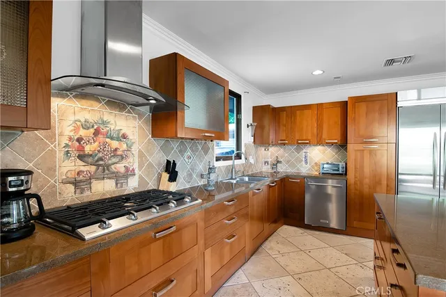 a kitchen with stainless steel appliances granite countertop a sink a stove and refrigerator
