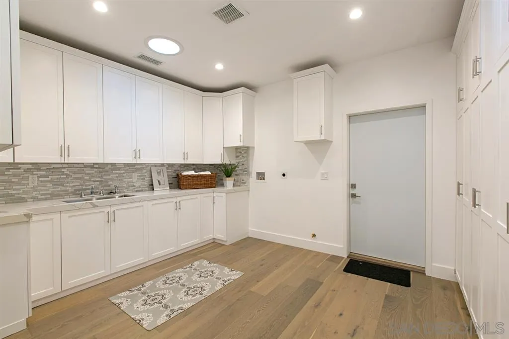 16582 Rio Vista Road San Diego, CA 92127 - Photo 12 of 20 a kitchen with granite countertop white cabinets and refrigerator