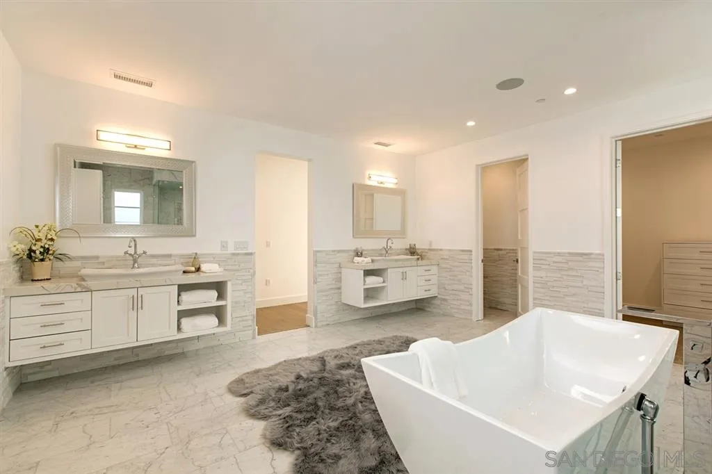 16582 Rio Vista Road San Diego, CA 92127 - Photo 14 of 20 a spacious bathroom with a double vanity sink a mirror and a bathtub