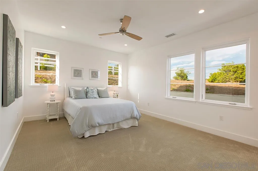 16582 Rio Vista Road San Diego, CA 92127 - Photo 15 of 20 a spacious bedroom with a bed and a large window