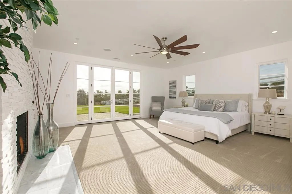 16582 Rio Vista Road San Diego, CA 92127 - Photo 16 of 20 a spacious bedroom with a large bed and a chandelier