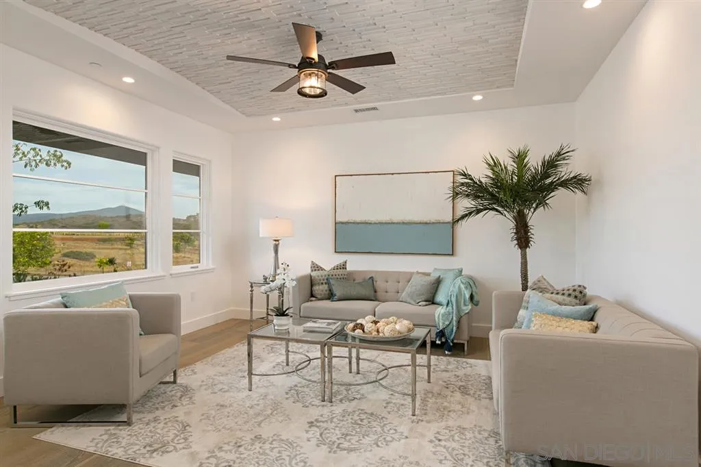 16582 Rio Vista Road San Diego, CA 92127 - Photo 10 of 20 a living room with furniture a large window with a dining table