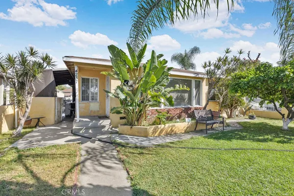 a view of a house with backyard and sitting area