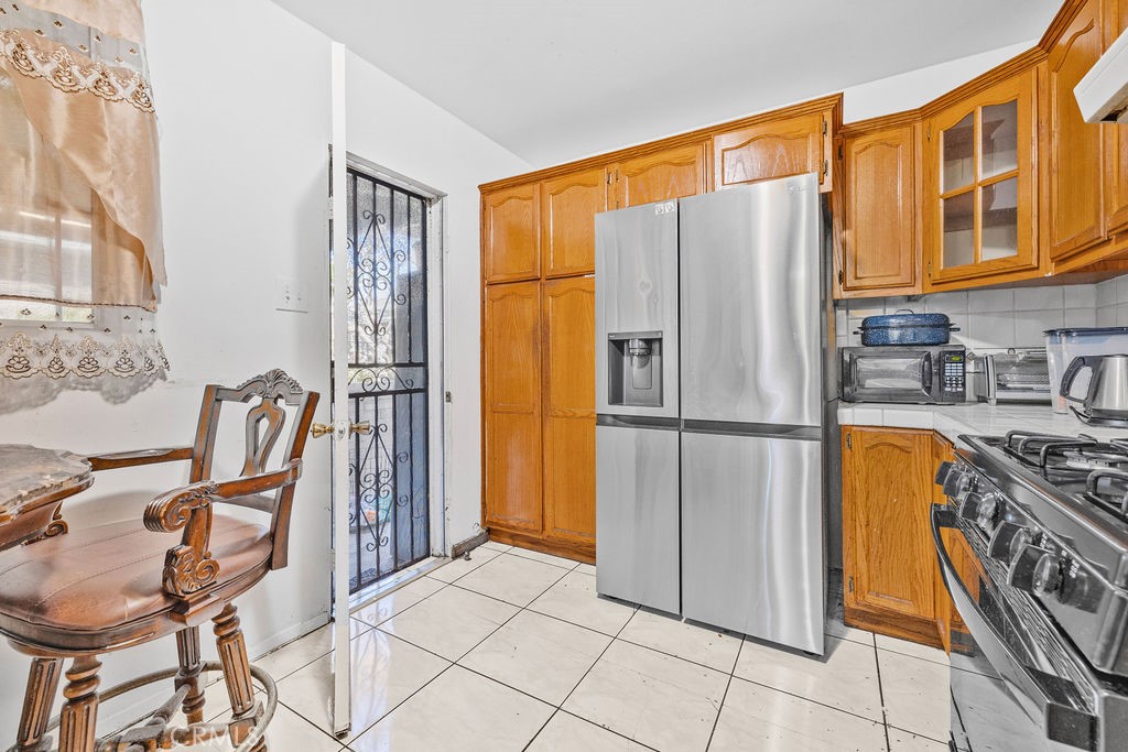 4237 Abbott Road Lynwood, CA 90262 - Photo 10 of 39 a kitchen with stainless steel appliances granite countertop a refrigerator a stove a washer and dryer