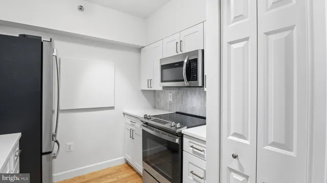 a kitchen with stainless steel appliances white cabinets and a stove
