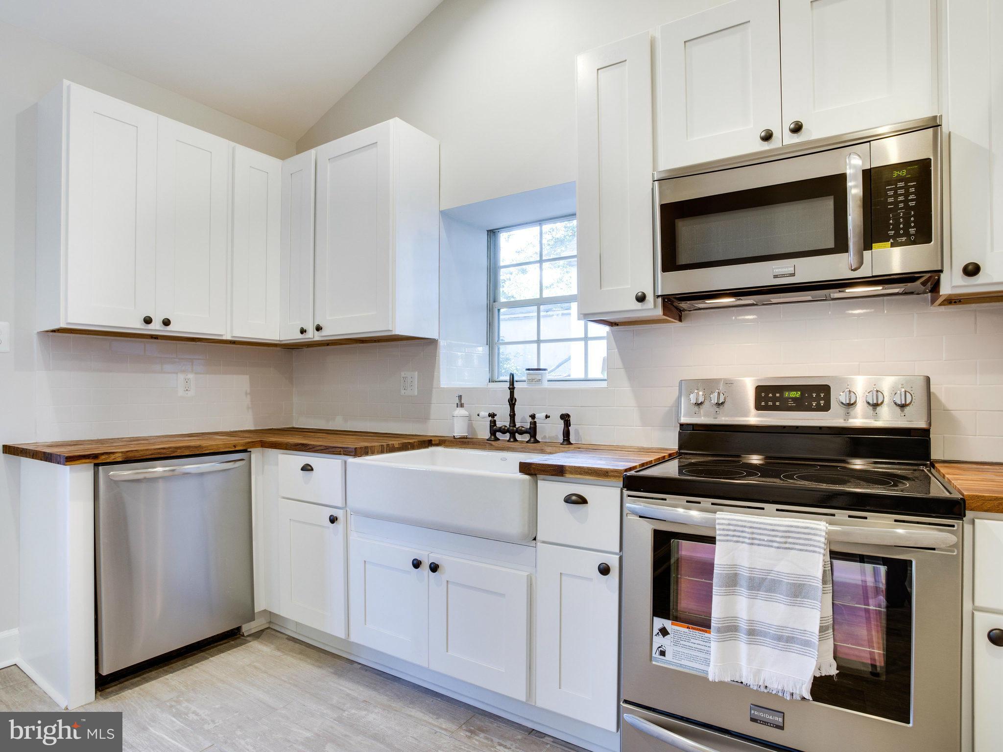 1704 Forestville Road Edgewater, MD 21037 - Photo 14 of 24 a kitchen with white cabinets and appliances