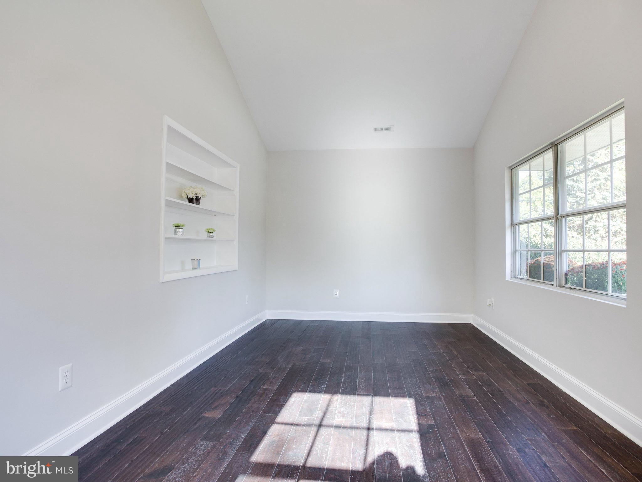 1704 Forestville Road Edgewater, MD 21037 - Photo 7 of 24 an empty room with wooden floor and windows