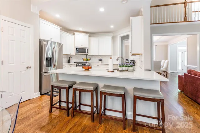 a kitchen with a table chairs refrigerator and cabinets