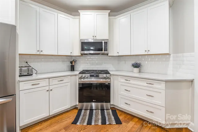 a kitchen with granite countertop white cabinets and white appliances