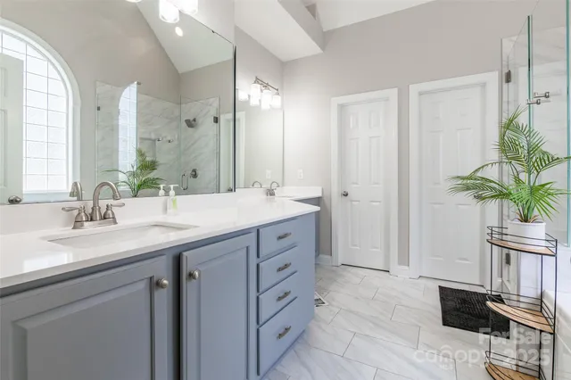 a spacious bathroom with a granite countertop sink a mirror a vanity and a bathtub