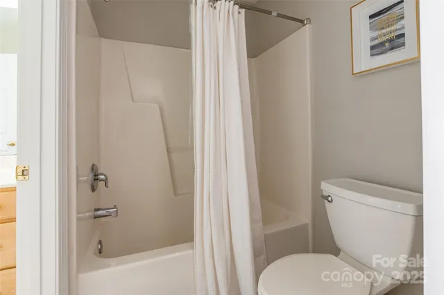 a white toilet sitting next to a bath tub