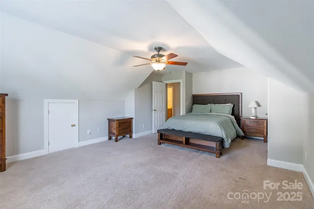 a spacious bedroom with a bed and a chandelier