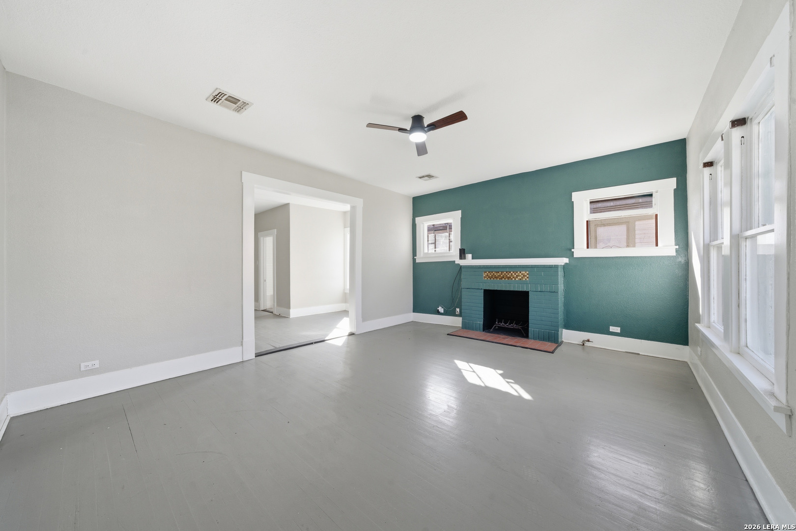 a view of a livingroom with a fireplace and window