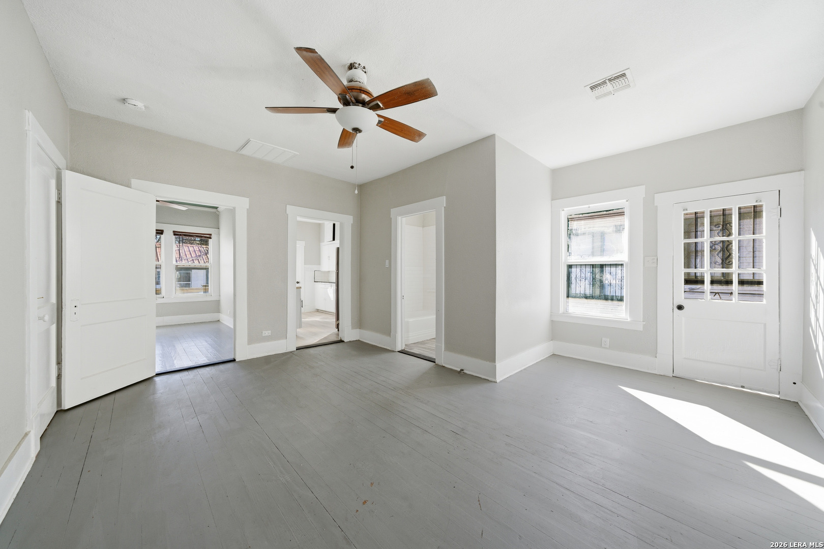 122 Biering Street, Unit 2 San Antonio, TX 78210 - Photo 3 of 8 a view of an empty room with chandelier fan and wooden floor