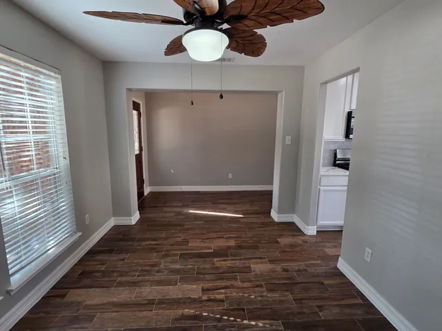 a view of a hallway with wooden floor and chandelier