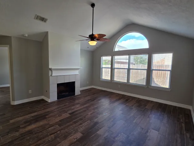 a view of a livingroom with a ceiling fan window and wooden floor