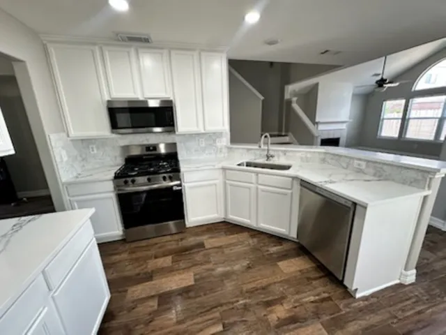 a kitchen with stainless steel appliances granite countertop a sink and stove top oven