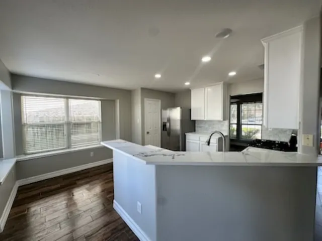 a kitchen with kitchen island a sink appliances and a large window