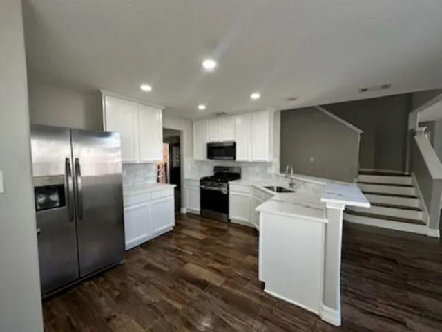 a kitchen with a refrigerator sink and cabinets