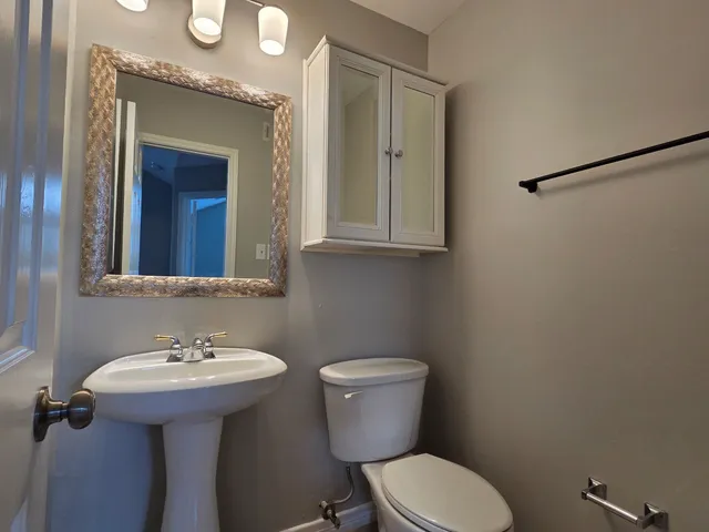 a bathroom with a toilet a sink and mirror