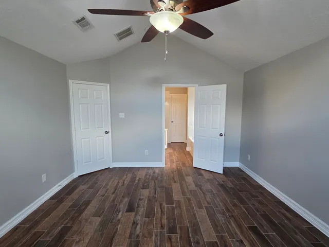a view of empty room with wooden floor