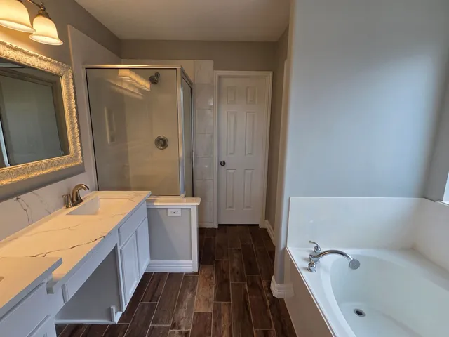 a bathroom with a tub sink and mirror