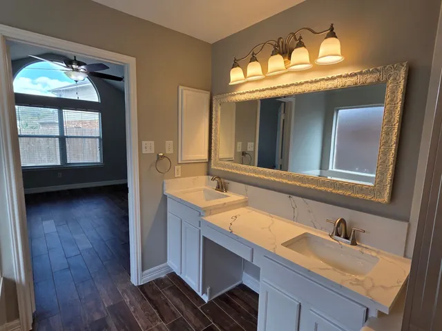 a bathroom with a granite countertop sink and a mirror