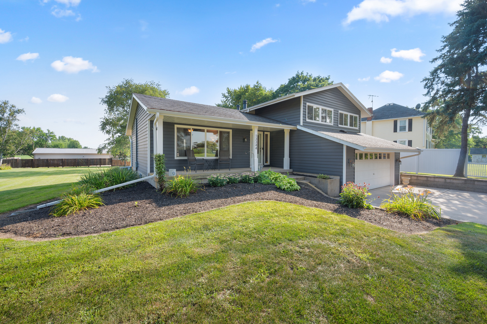 13344 Base Line Road Kingston, IL 60145 - Photo 3 of 38 a front view of a house with a yard and garage