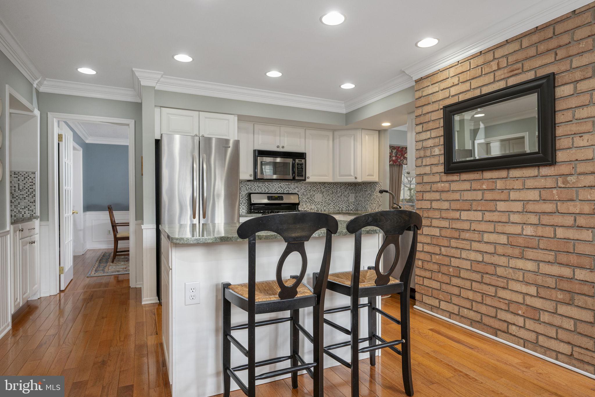 207 Overcreek Road Phoenixville, PA 19460 - Photo 12 of 47 a kitchen with stainless steel appliances granite countertop a stove top oven a sink a refrigerator with grey cabinets and wooden floor
